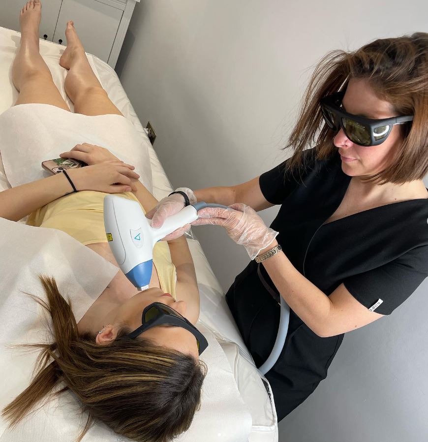 Alessia performing laser hair removal on client on facial area